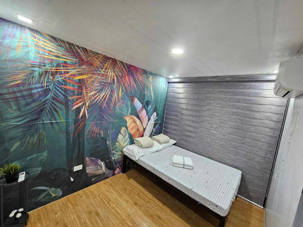um quarto com um banco em frente a um mural em Jolie Joe's Bed and Breakfast em Tagudin