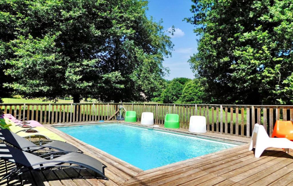 une piscine avec des chaises et une terrasse en bois dans l'établissement Le Moulinot, à Sarlat-la-Canéda