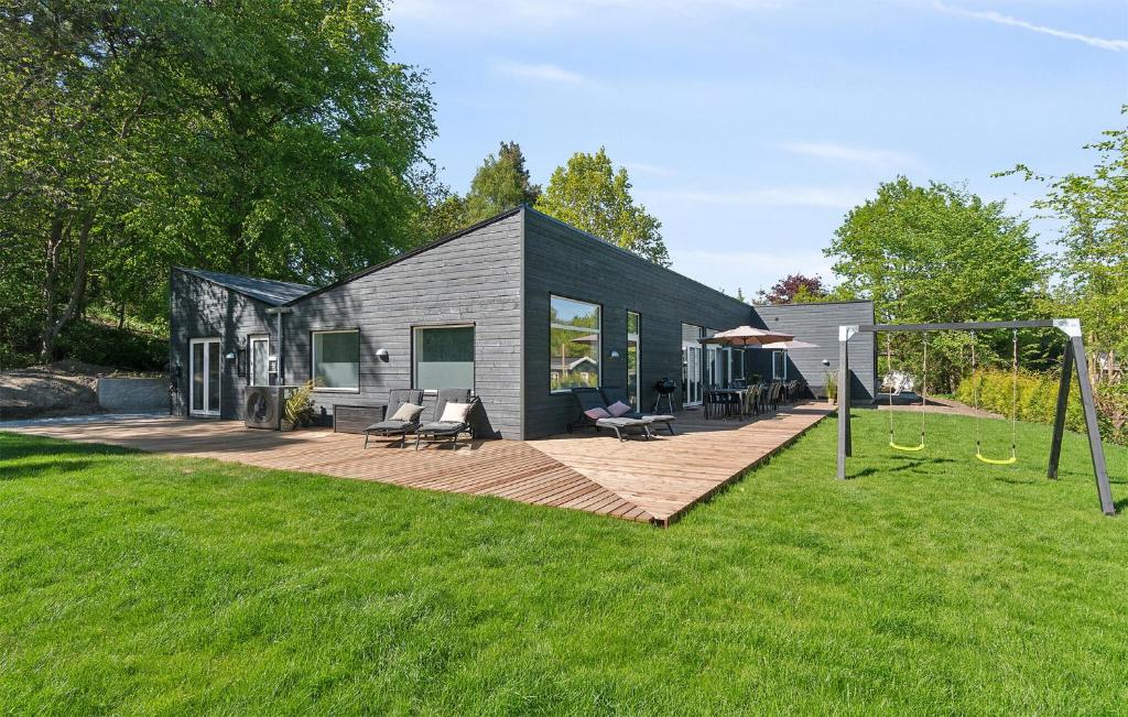 a small black house on a wooden deck at Amazing Home In Vejby With Kitchen in Vejby