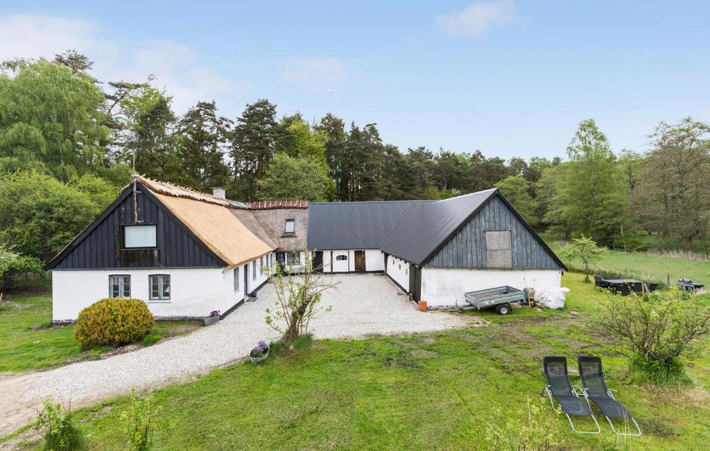 a large white barn with a black roof at Amazing Apartment In Tisvildeleje in Tisvildeleje