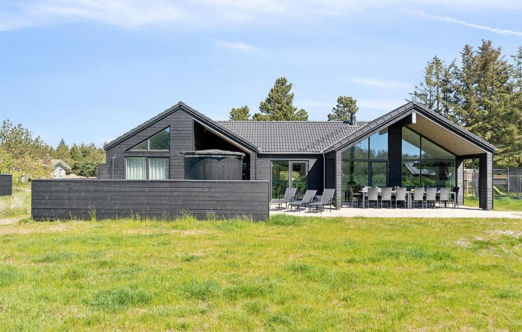 a modern house with a black roof at Gorgeous Home In Blåvand With Sauna in Blåvand