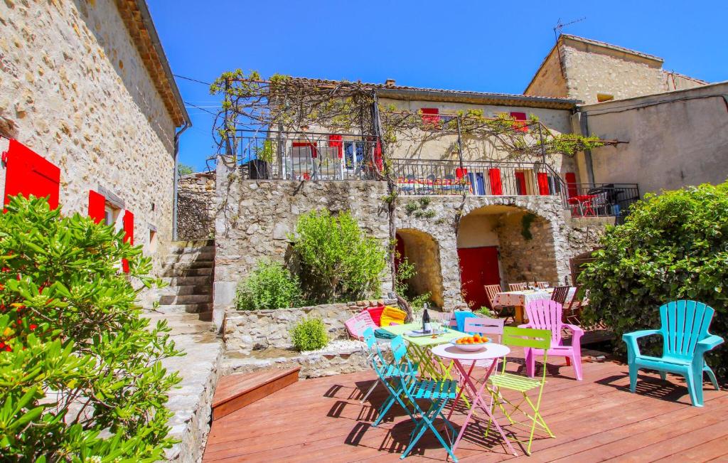 une terrasse avec des chaises et des tables colorées en face d'un bâtiment dans l'établissement Beautiful Home In Gras, à Gras