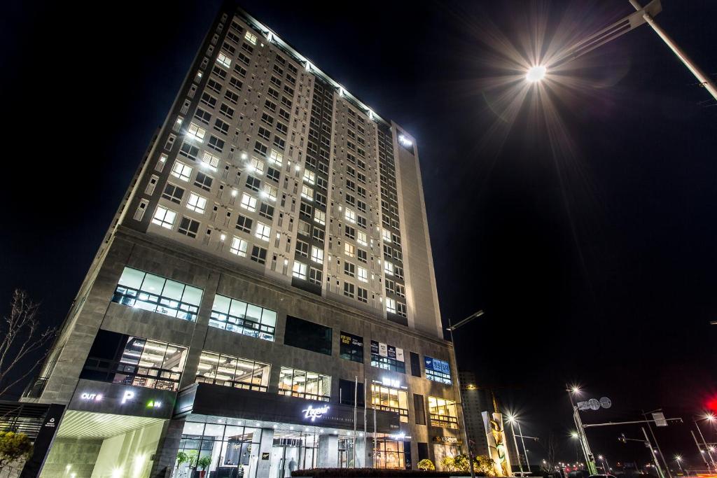 un edificio alto di notte con luci accese di Hotel Logenir a Gimcheon