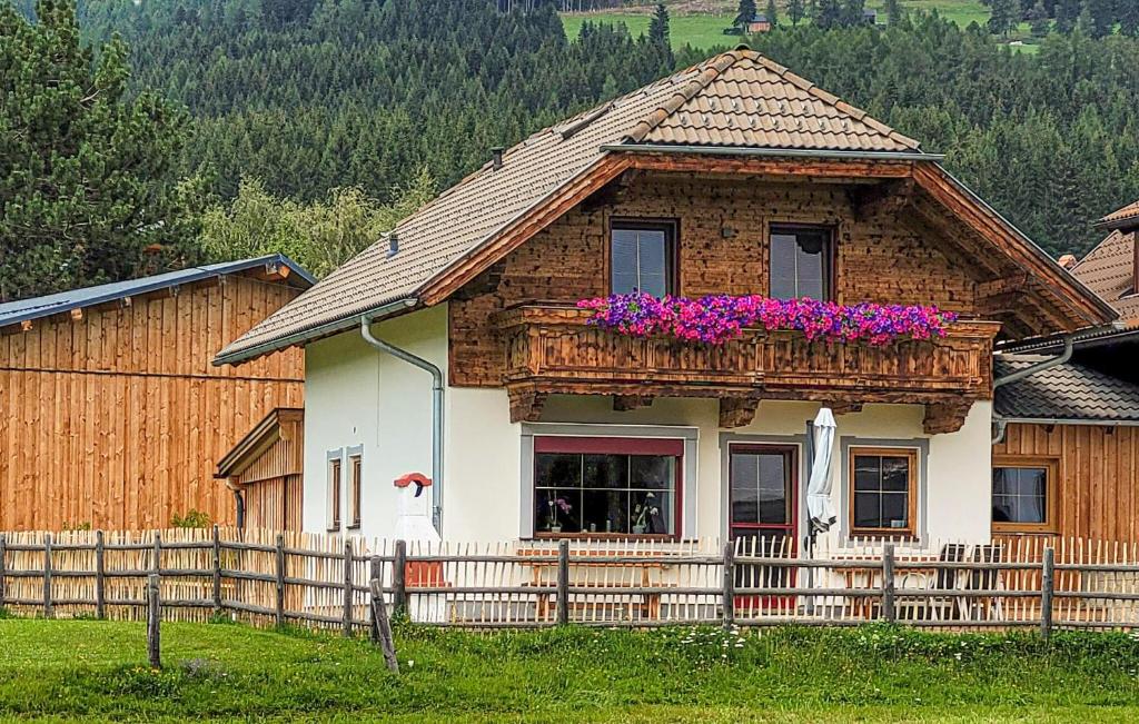a house with a balcony with purple flowers on it at Chalet In Mariapfarr in Mariapfarr