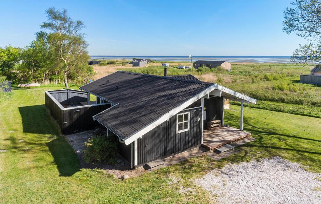 a small house with a roof on a field at Four-Bedroom Holiday Home In Orsted in Ørsted