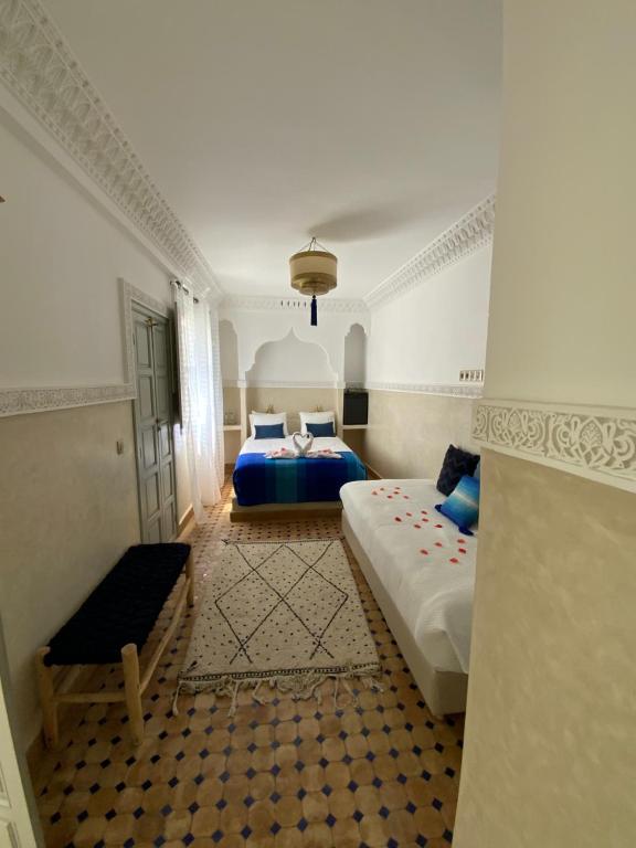 Un dormitorio con 2 camas y una silla. en Riad Magnolia & SPA, en Marrakech