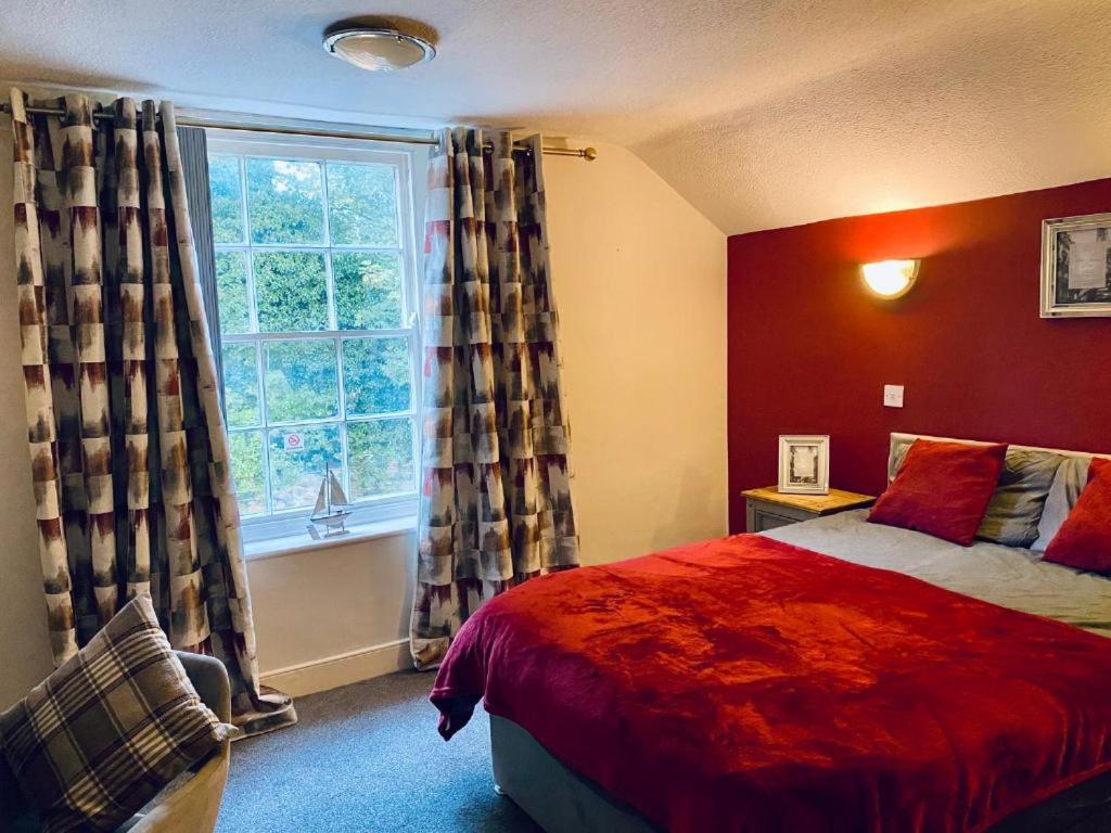1 dormitorio con cama y ventana grande en Blue Bell, en Rothwell