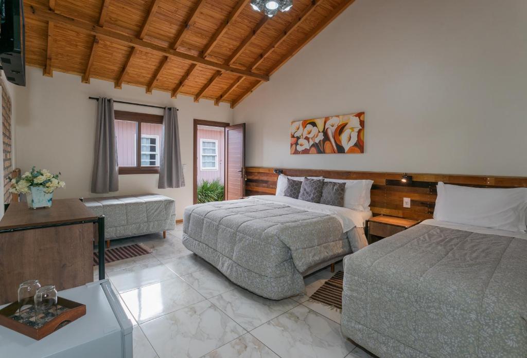 um quarto grande com 2 camas e um sofá em Pousada Flor de Tuna em Urubici