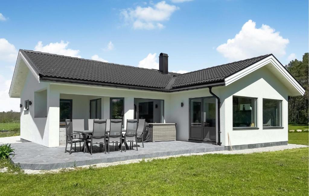 a small house with a patio and chairs at 3 Bedroom Cozy Home In Gotlands Tofta in Tofta