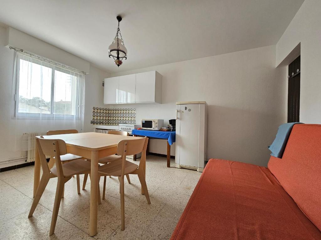 une cuisine et une salle à manger avec une table et un réfrigérateur dans l'établissement Appartement lumineux à 150m de la plage avec WiFi - 4 personnes - Animaux sur demande - FR-1-476-218, à La Faute-sur-Mer