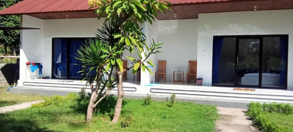 una casa con una palmera delante en Giri Homestay, en Amed