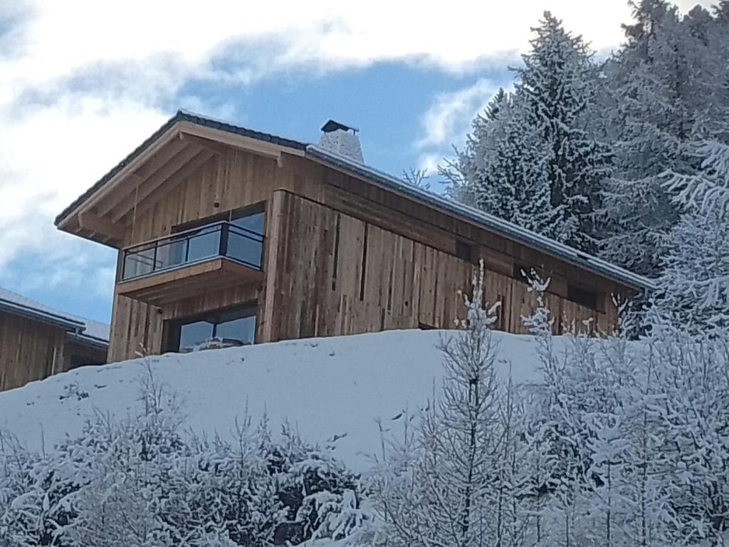 une maison au sommet d'une colline enneigée dans l'établissement Chalet neuf 2024 pour 12 pers. avec jacuzzi, ski-room et parking à La Plagne - FR-1-755-15, à Aime La Plagne