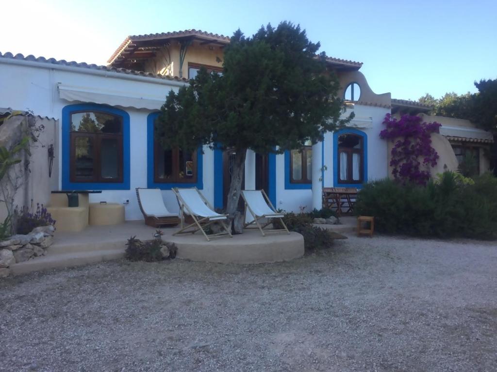 uma casa azul e branca com cadeiras em frente em Casa Goro Formentera em Playa Migjorn