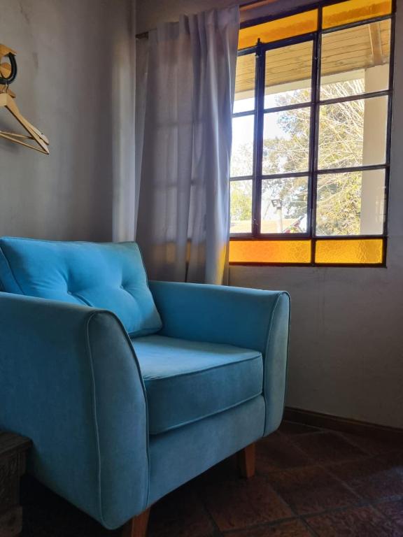 um sofá azul numa sala de estar com uma janela em Tordillo B&B em Chascomús