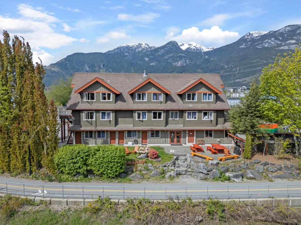uma casa grande com montanhas ao fundo em Squamish Adventure Inn em Squamish