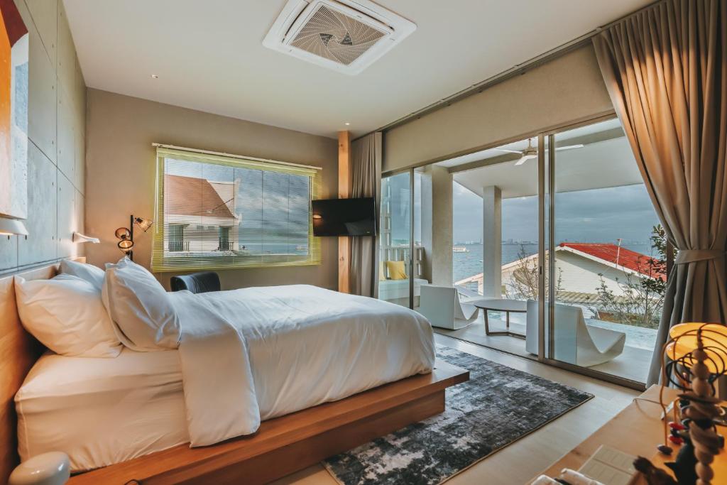 um quarto com uma cama e vista para o oceano em อาทิตย์ รีสอร์ท เกาะล้าน em Ko Larn