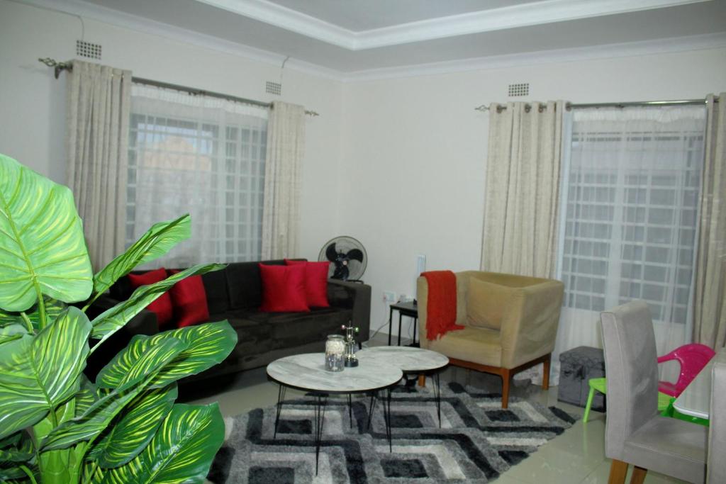 uma sala de estar com um sofá e uma mesa em Your home away from home em Lusaka