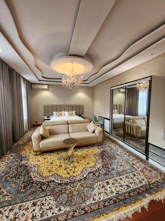 HOTEL DEHLAVI o في دوسهانبي: غرفة معيشة كبيرة مع أريكة وسرير