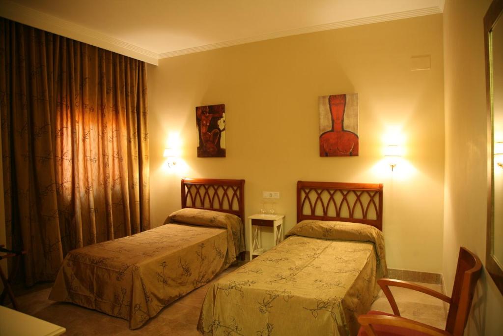 Łóżko lub łóżka w pokoju w obiekcie Hotel Torre del Oro