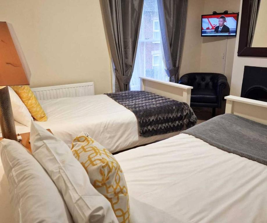 ノリッジにあるStay Norwich Apartments Pottergateのベッド2台とテレビが備わるホテルルームです。
