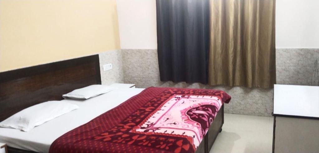 - une chambre avec un lit et une couverture rouge dans l'établissement Goroomgo Kunj Residency Mathura Near Bus Stand - Parking Facility & Restrurant, à Mathura