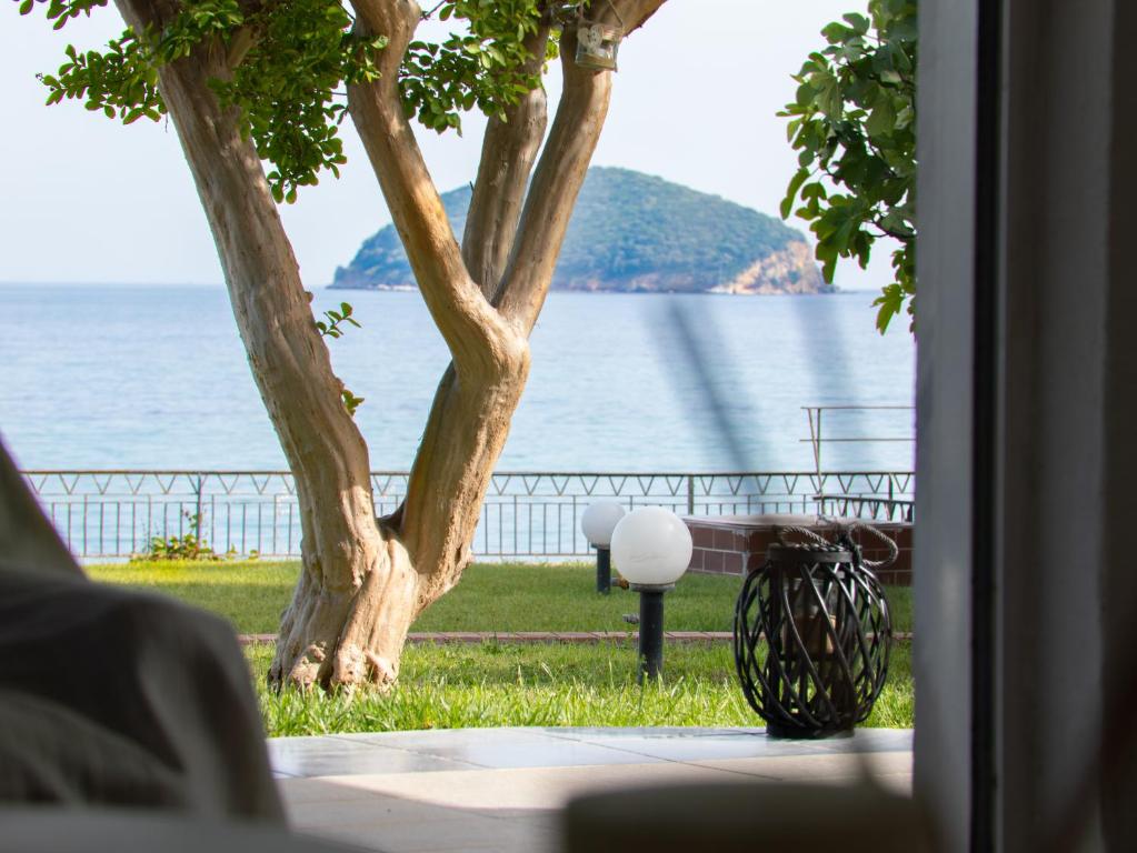 a view of the water from a room with a bench at The House On The Beach in Paleo Tsifliki