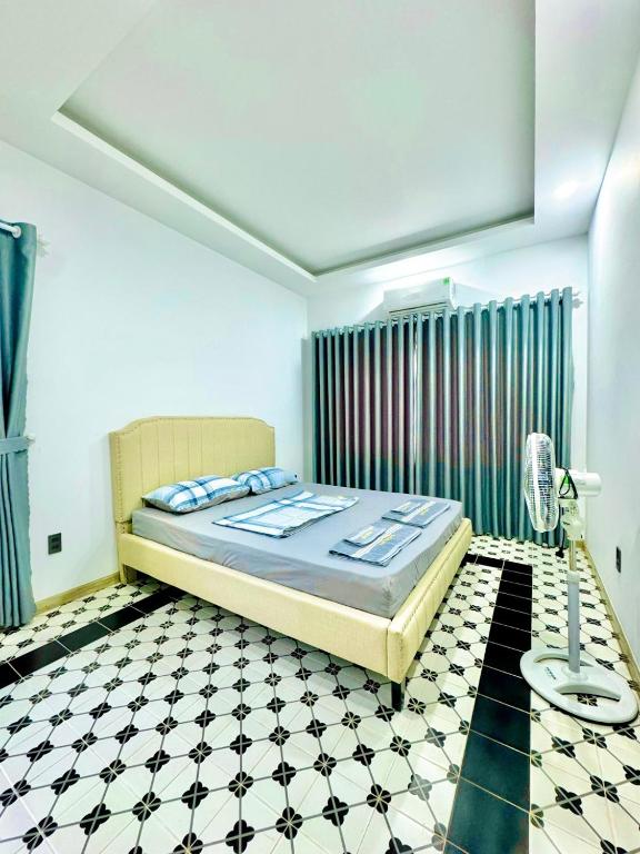 a bedroom with a bed and a black and white tiled floor at Nhà Sói Hồ Cốc in Xuyên Mộc