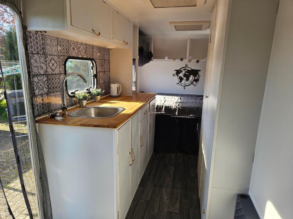 a kitchen in an rv with a sink at Mietwohnwagen inklusive Stellplatz & Strom - Dixi-WC in Carpin
