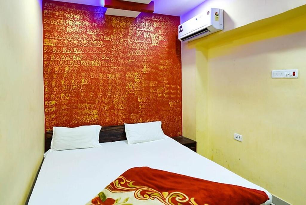1 dormitorio con cama y pared roja en Hotel Atithi Galaxy Kanpur Near Railway Station Kanpur - Wonderfull Stay with Family en Kānpur