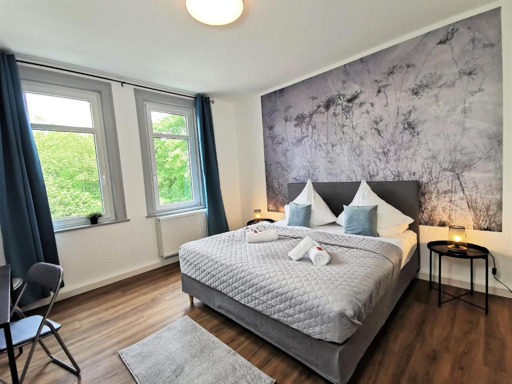 um quarto com uma cama grande e almofadas azuis em BohnApartments - Stadtblick Zechenhaus - Balkon - gratis Parkplatz - WLAN - sehr ruhig - barrierearm em Ilmenau