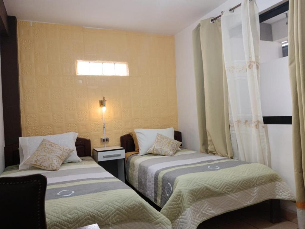 1 Schlafzimmer mit 2 Betten und einem Fenster in der Unterkunft Casa Qura Qura in Cochabamba
