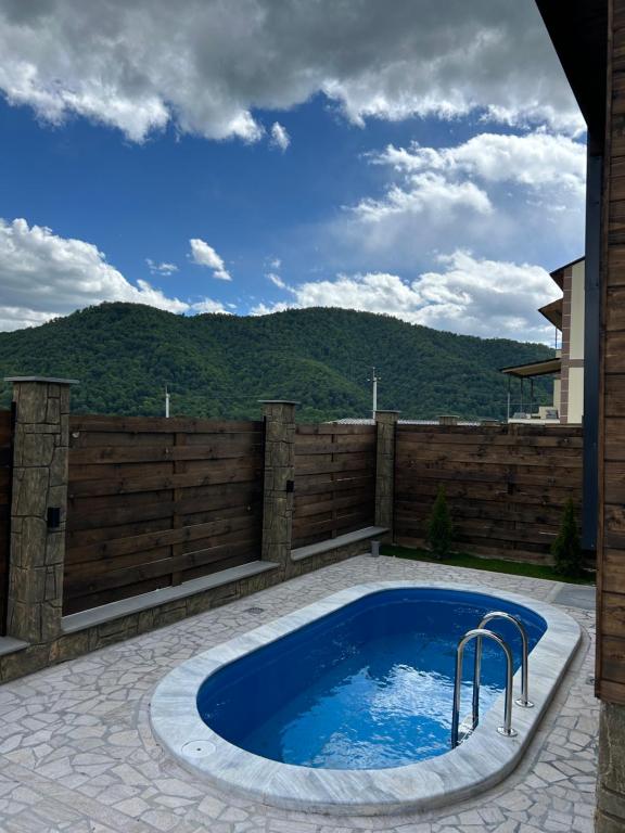 una piscina su un patio con recinzione in legno di Swiss House Dilijan a Dilijan