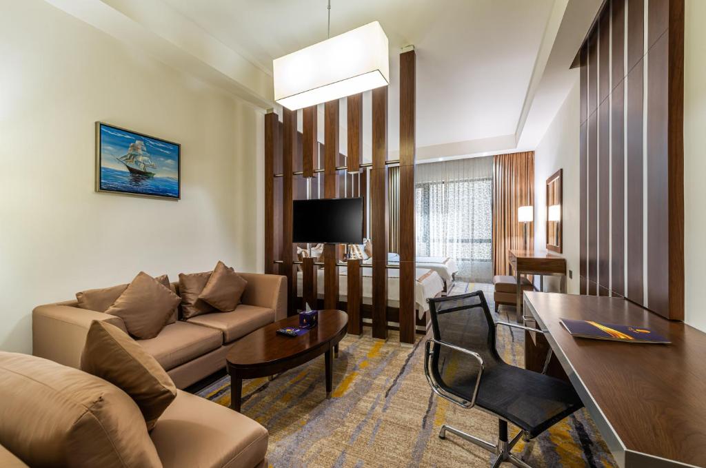 Una televisión o centro de entretenimiento en Sulaf Luxury Hotel