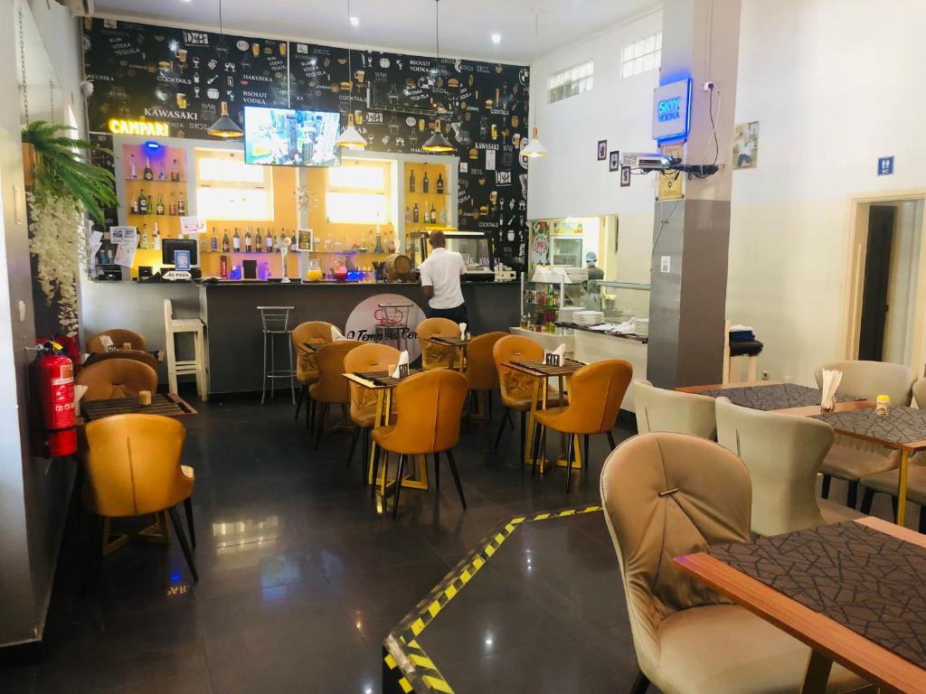 un restaurante con mesas y sillas y un bar en CHIP RESIDENCIAL en Luanda