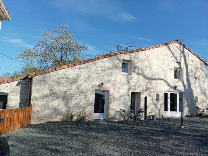 un grand bâtiment blanc avec une clôture devant lui dans l'établissement L'évidence 2 à 4 personnes, à La Jaudonnière