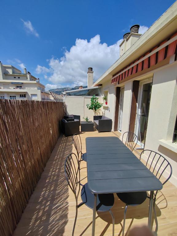 une table et des chaises bleues sur une terrasse dans l'établissement T1 avec grande terrasse, hypercentre ,climatise, à Toulon