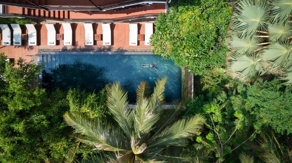 an overhead view of a swimming pool with palm trees at The Urban in Siem Reap