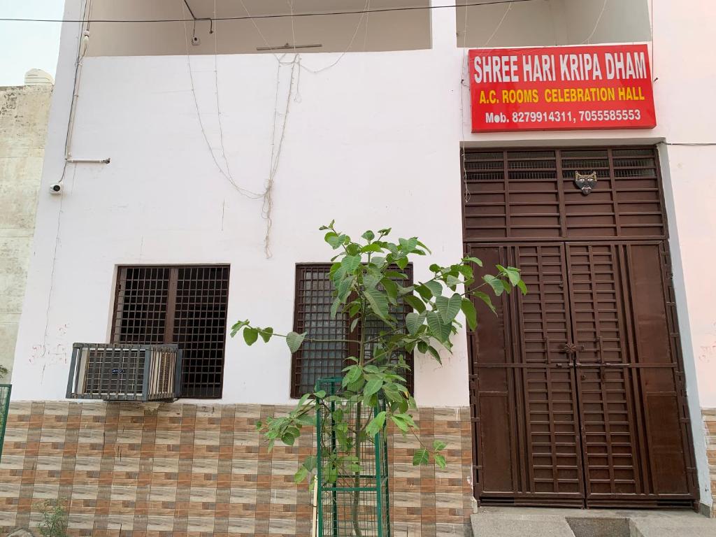 um edifício com uma porta castanha e um sinal nele em Shree Hari Kripa Dham em Jait