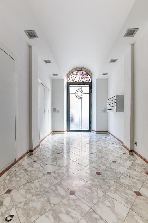 an empty room with a large window and a door at Elena House Apartments in Viareggio