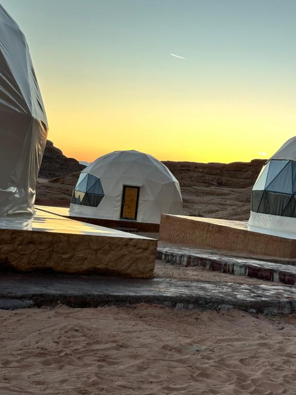 duas tendas no deserto com o pôr do sol ao fundo em Sarah's camp em Wadi Rum