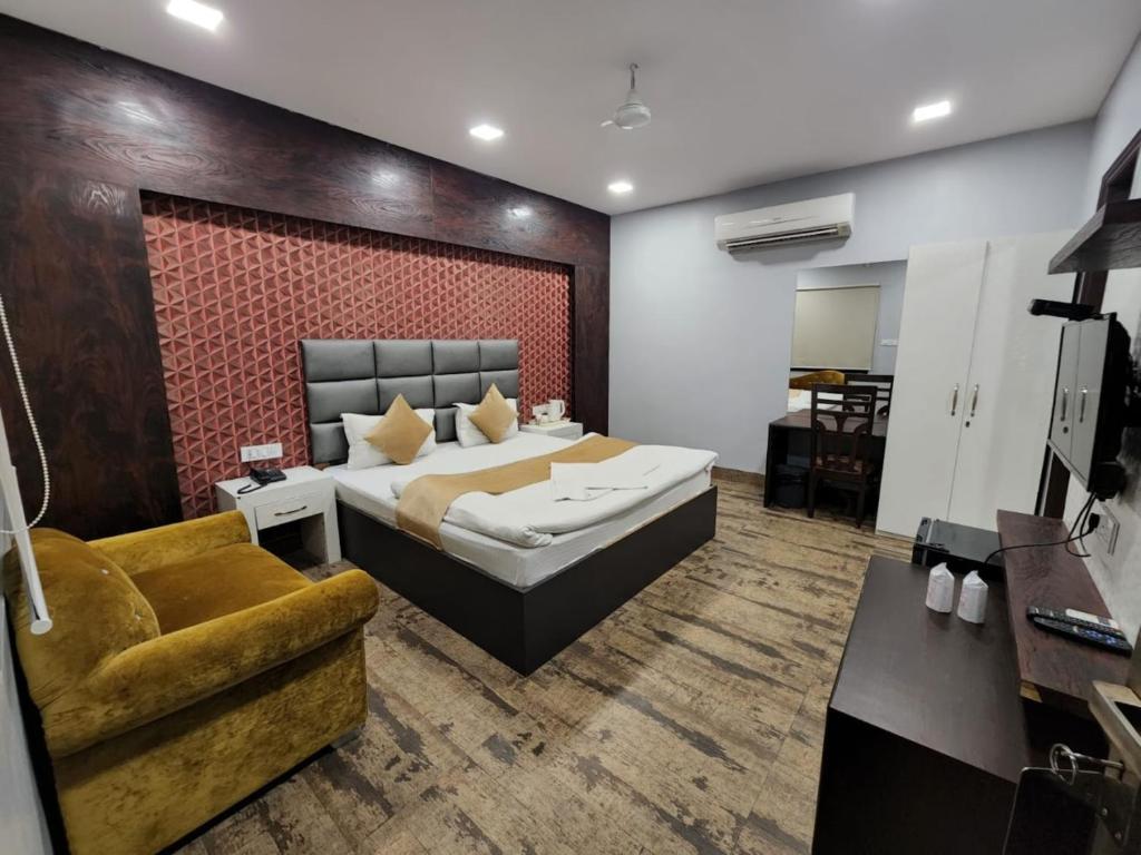 a bedroom with a large bed and a couch at Hotel Mandakini Royale Near PVR Deep Cinema Hall Kanpur in Kānpur