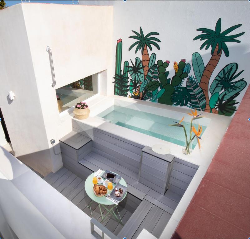 baño con piscina con palmeras en la pared en Casa 95 Sevilla, en Sevilla
