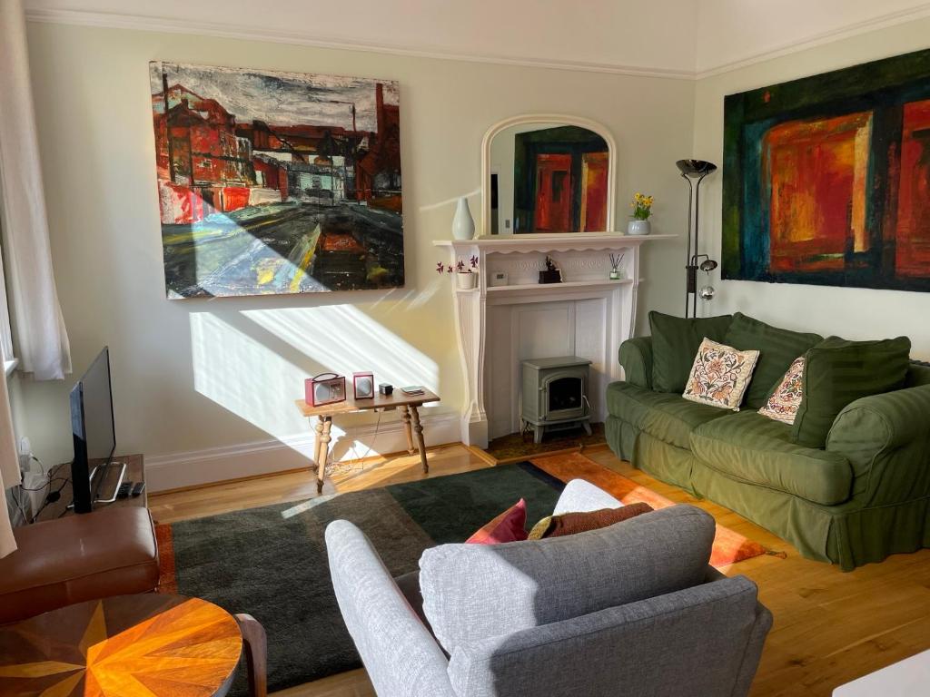 uma sala de estar com um sofá e uma cadeira em Airy Apartment Sefton Park em Liverpool
