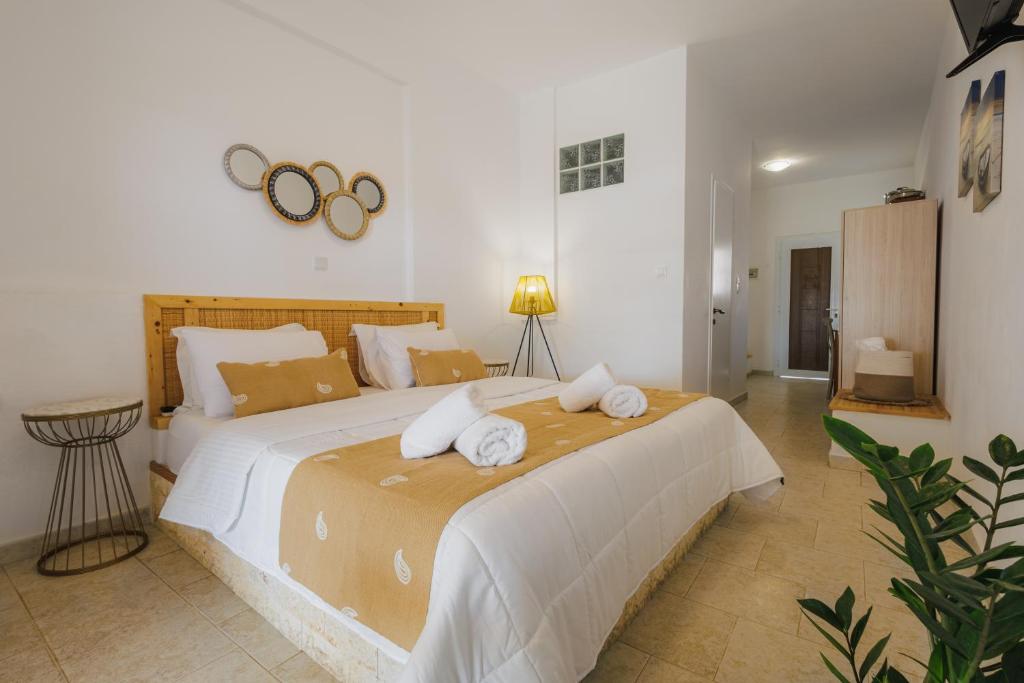 a bedroom with a large bed with towels on it at Studios Eliza in Livadi
