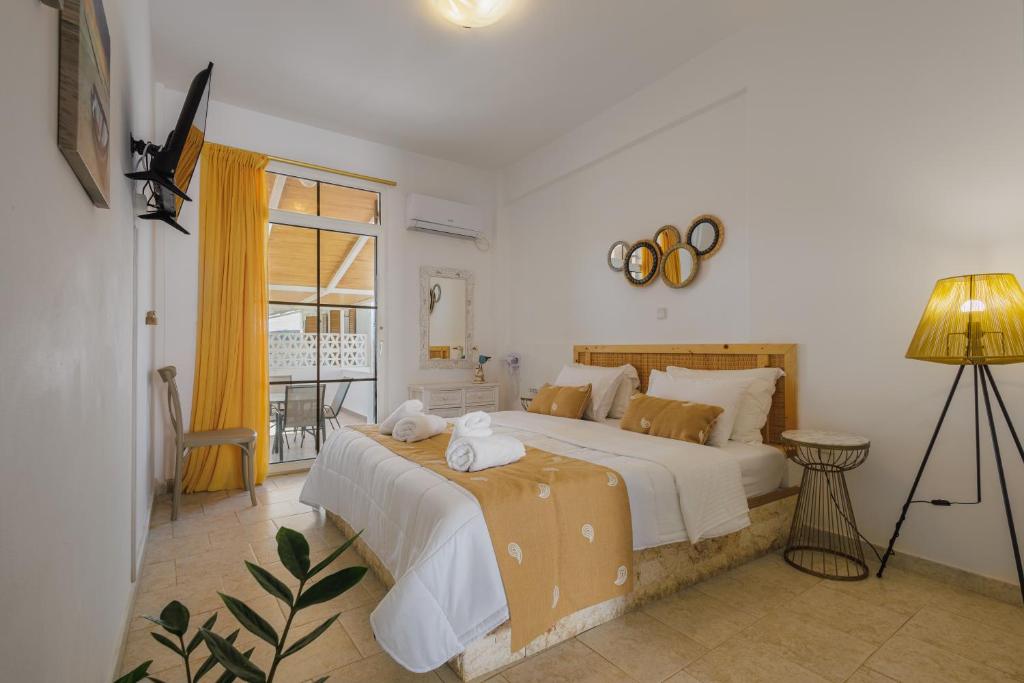 a bedroom with a large bed and a window at Studios Eliza in Livadion