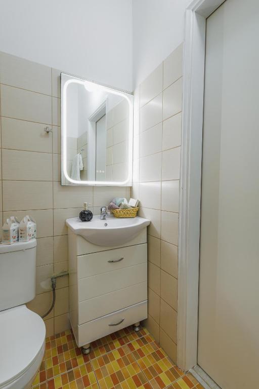 a bathroom with a sink and a mirror and a toilet at Studios Eliza in Livadi