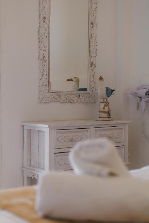 a mirror and a dresser with a duck on it at Studios Eliza in Livadi