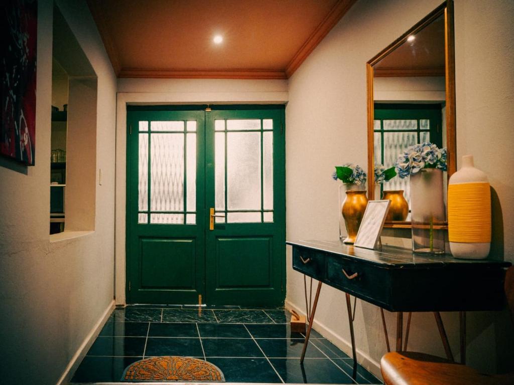 a hallway with a green door and a mirror at The Green Door Cottage in Roodepoort