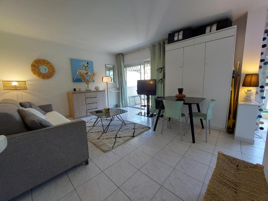 un salon avec un canapé et une table dans l'établissement Studio Montrose Cannes - Axelle Loc'Appart, à Cannes