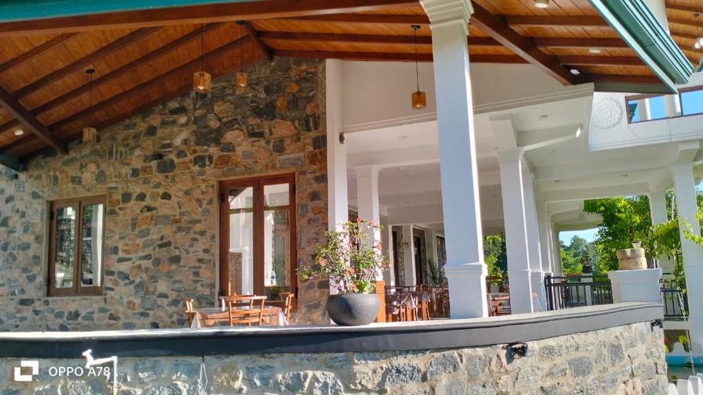un porche de una casa con una pared de piedra en Jacks Lounge and Hotel, en Kandy